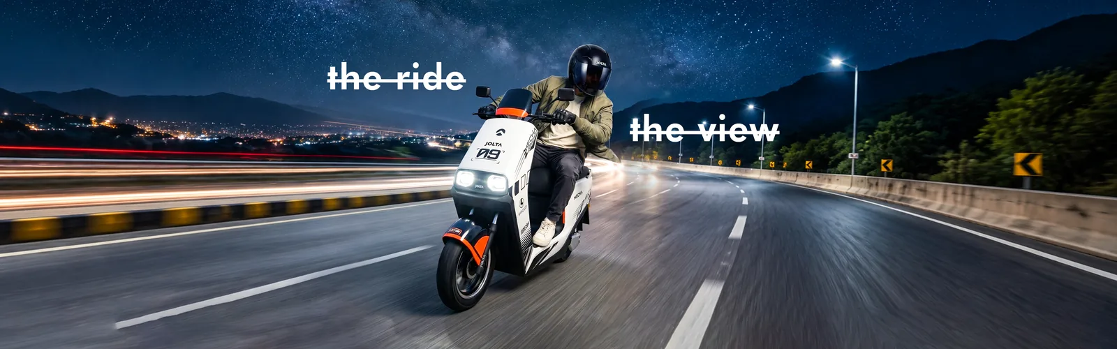 Rider on a white Jolta Mecha electric scooty on a highway at night